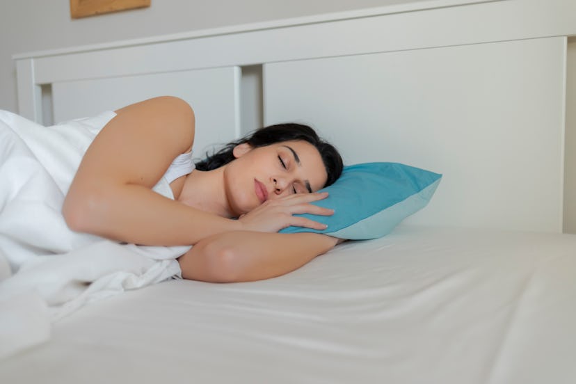 A person sleeps on white sheets with a blue pillow. Your sleep hygiene is even more important during...