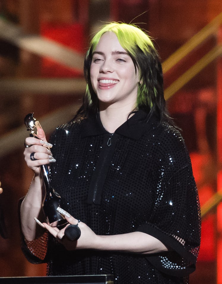 Billie Eilish accepts an award on-stage.