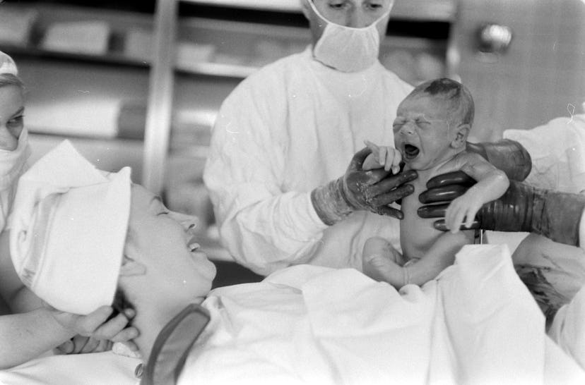 This photo from 1958 is the perfect "first look" between mom and brand new baby.