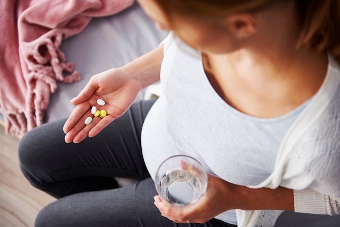 pregnant woman taking prenatal vitamins
