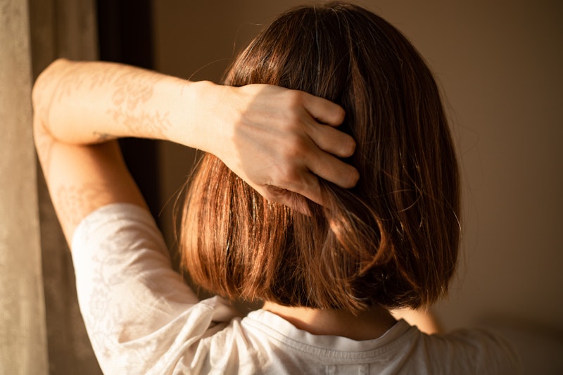 A woman runs her hand through her hair. Endometriosis can cause intense pain, and treatments can inc...