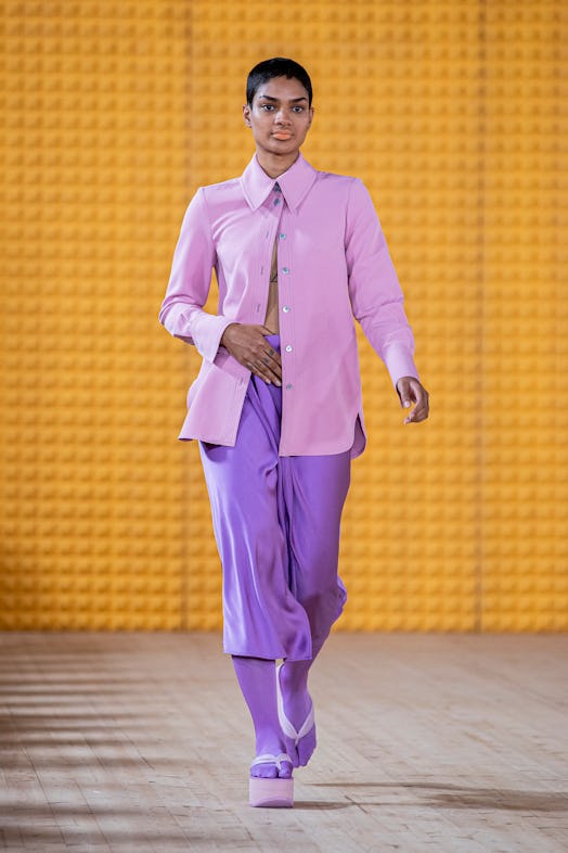 Model wears lilac button-down shirt paired with lavender silk capri pants by Stine Goya