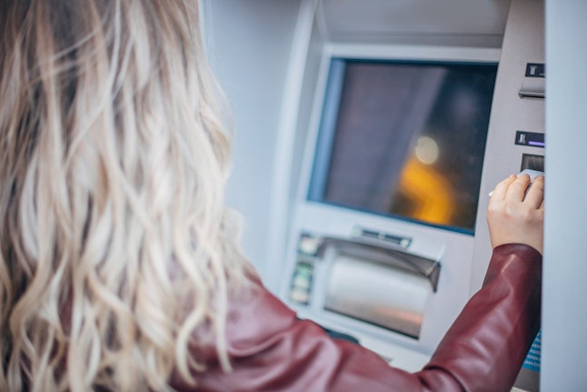 A woman with white hair at an ATM. Hair color is one potential effect of stress on the body.