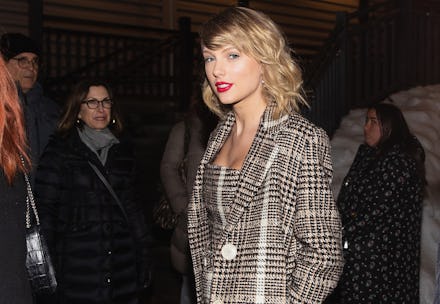 Taylor Swift posing in a grey checked blazer and a matching dress