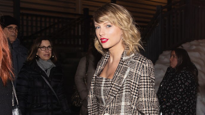 Taylor Swift posing in a grey checked blazer and a matching dress