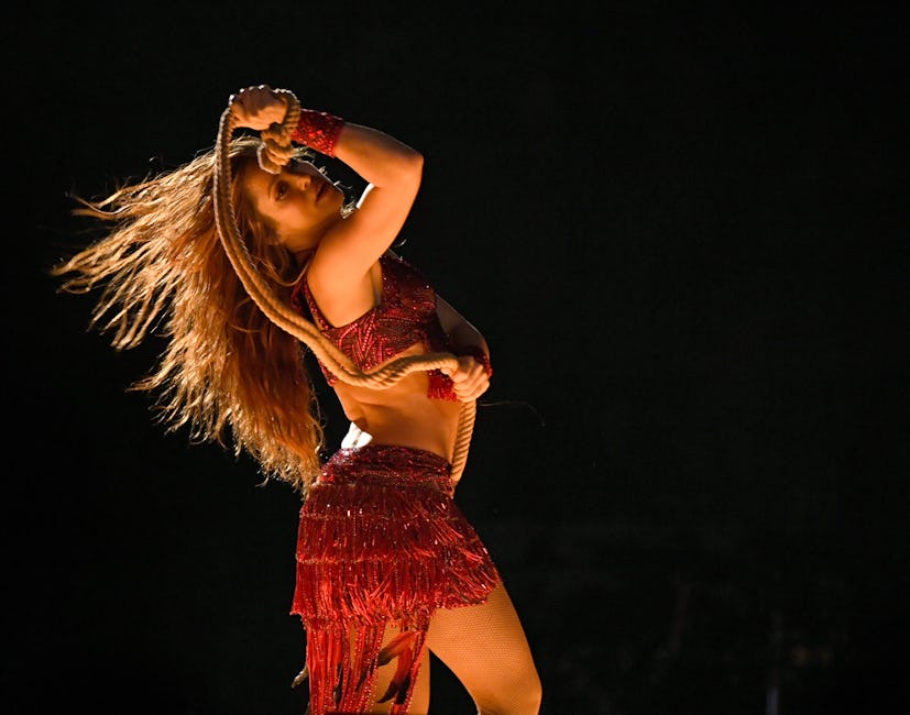 Shakira performs at the Super Bowl halftime show in a red fringe outfit, holding a rope