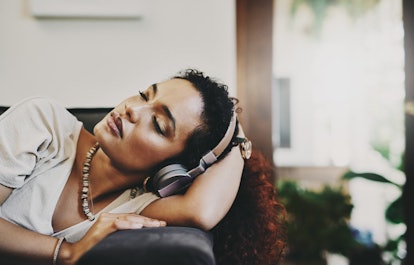 A woman sleeps with headphones. Listening to podcasts with emotional resonance may affect your dream...