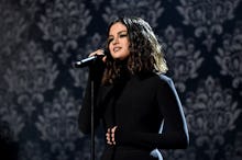 Selena Gomez performing on stage in a black dress during breakup bop season