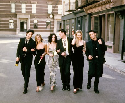 The cast of Friends walking all together hand in hand down the street