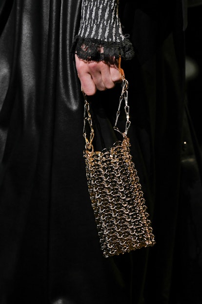 A woman holding a golden chain bag