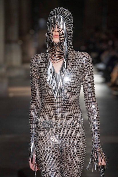 A female model walking in a silver knight bodysuit at a fashion show