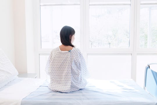 woman in hospital bed looking out window