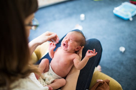 woman holding a newborn on her legs