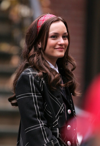 Leighton Meester in a headband with curled hair wearing a black plaid jacket