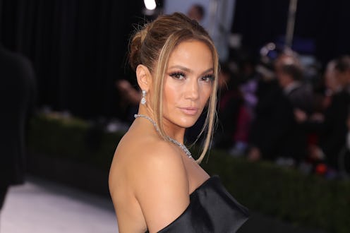 Jennifer Lopez wearing a black dress and diamond jewelry with a tousled updo