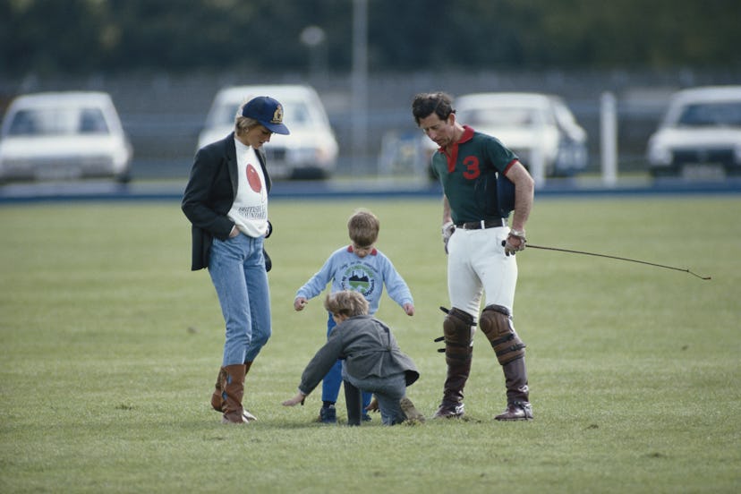 Prince Harry plays in a field with his family