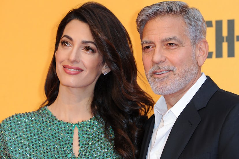 Amal Clooney wearing Charlotte Tilbury's Pillow Talk lipstick while posing with George Clooney on th...