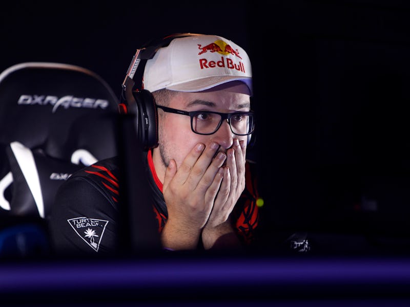 A gamer with a Red Bull cap and black headphones