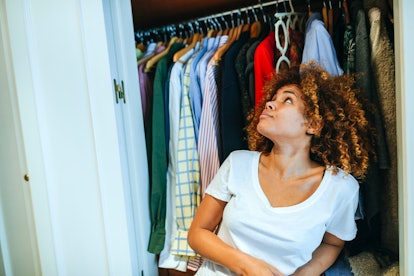 A woman looks up at her freshly-organized closet.