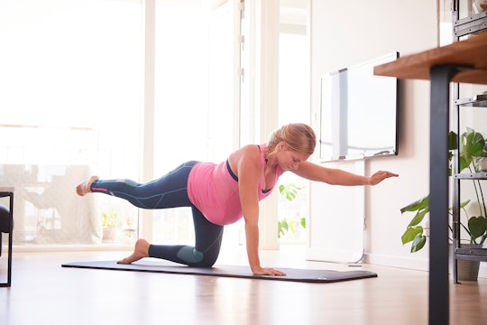 pregnant woman in leggings doing yoga
