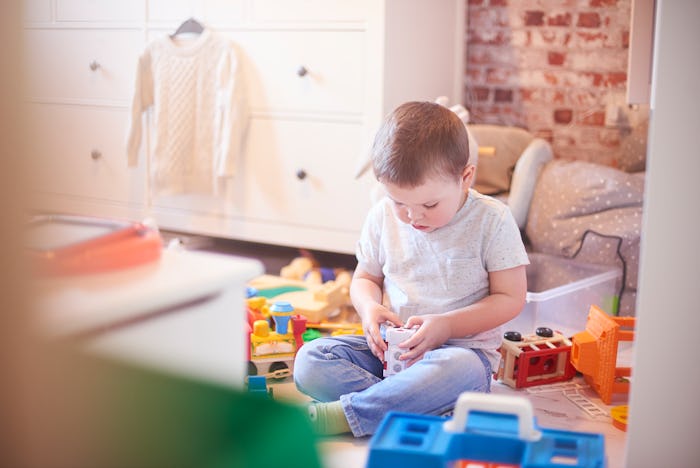 a little boy playing by himself with toys