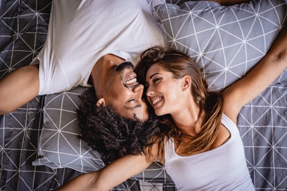 A couple lies in bed, ready to have sex for the first time