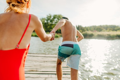 Um casal corre de uma doca para saltar para um lago. Ter sexo pela primeira vez como homem é diferente para todos
