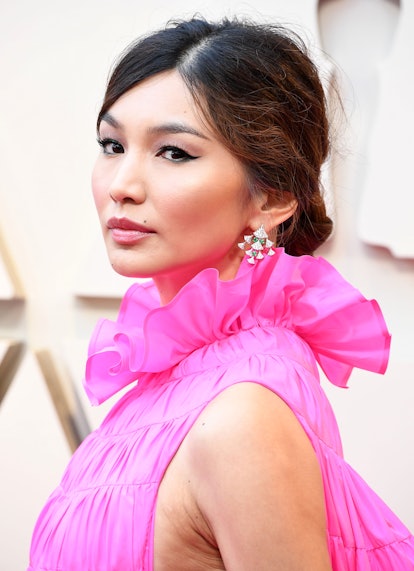 Gemma Chan's low bun was complemented by her bright pink dress and sparkling earrings