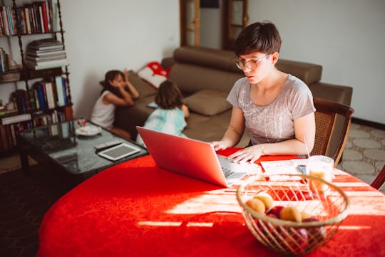mom working from home as kids play in background