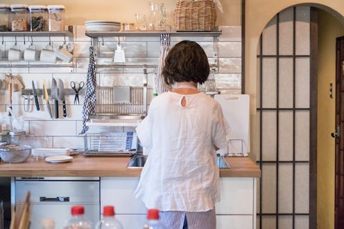 A woman in her kitchen cooking while practicing social distancing. Food scarcity worries can lead to...