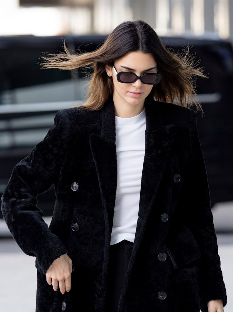 Kendall Jenner steps out in a black coat and matching shades.