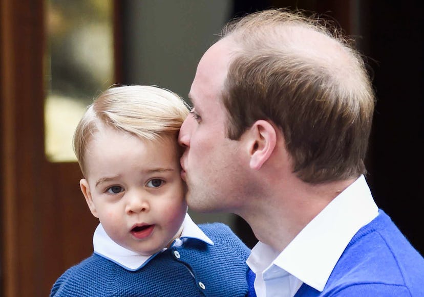 Prince William kissing Prince George.