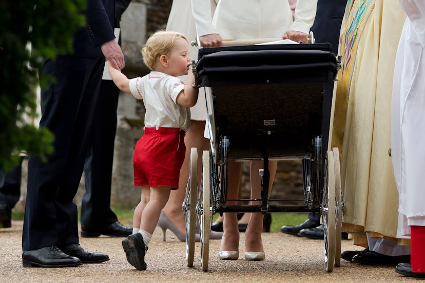 Prince George looks in on his baby sister in her pram.