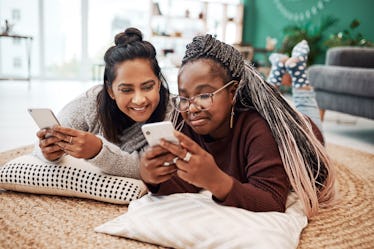 Two young women lay on the flour and try out Pinterest's new "Today" tab.