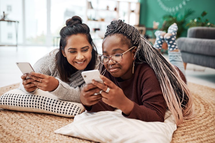 Two young women lay on the flour and try out Pinterest's new "Today" tab.