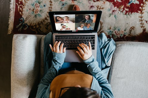 A woman videochats with family on a laptop Talking to others on video chat when you're at home can h...