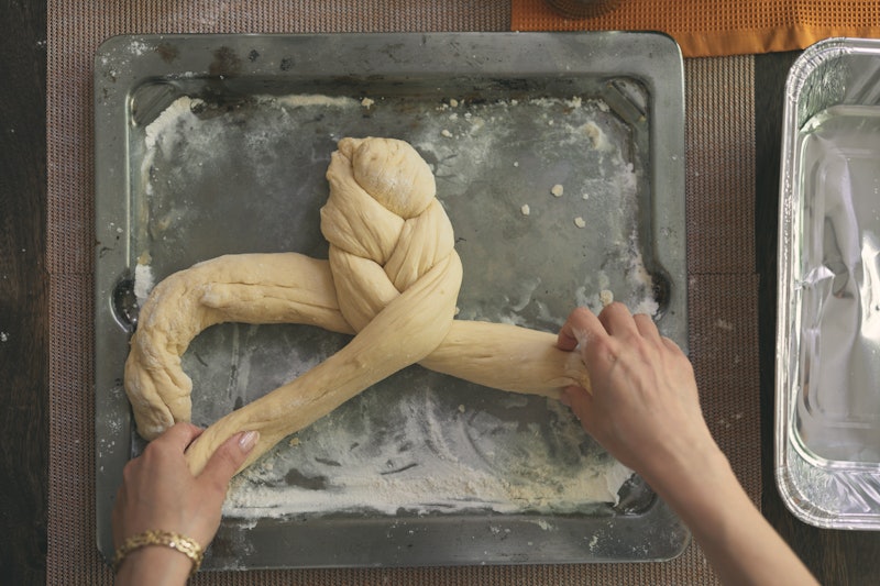 A woman braids challah. Bread-baking is one social-distancing project often found on Instagram
