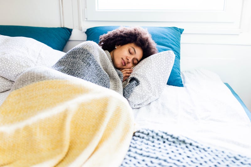 A person sits up and stretches in bed. Daylight Saving Time's effects on your body are variable, but...