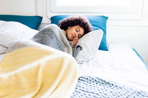 A person sits up and stretches in bed. Daylight Saving Time's effects on your body are variable, but...