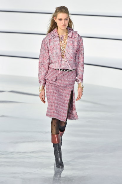 A model at the Chanel Fall 2020 show in a pink floral shirt, pink tweed skirt, 