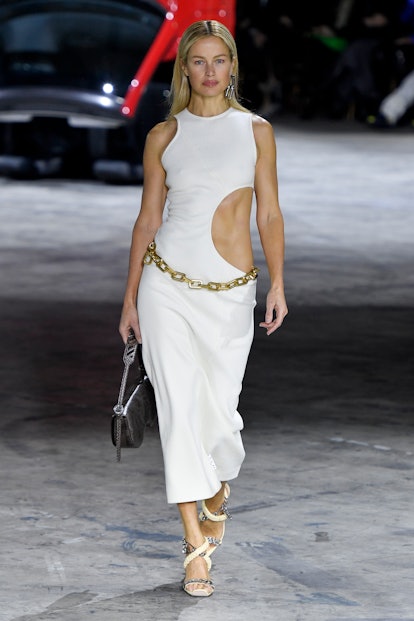 A blonde model walking in a white cut-out dress at the Paris Fashion Week Fall/Winter 2020