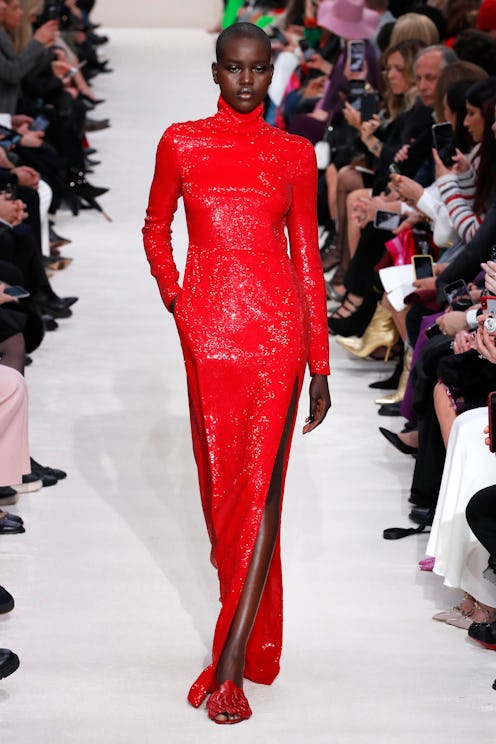 A model walking the runway in a maxi dress with a side slit by Valentino
