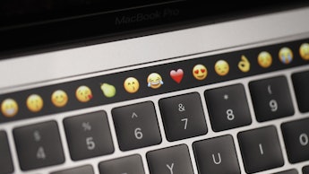 A photo of a keyboard with emojis above it