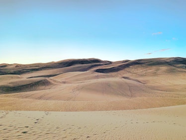 Great Sand Dunes National Park is covered in footprints on a sunny day.