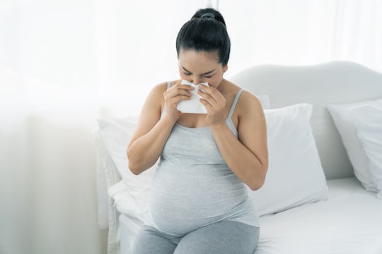 a pregnant woman sneezing