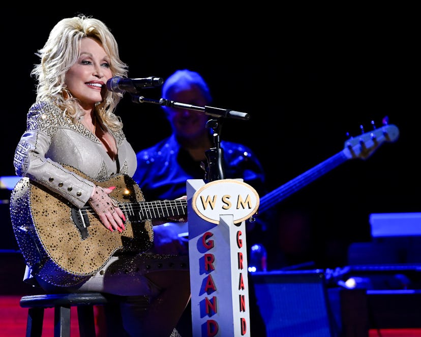 Dolly Parton playing a guitar during a concert