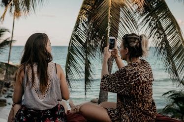 Two girls sit and look at the ocean while on spring break in Mexico.