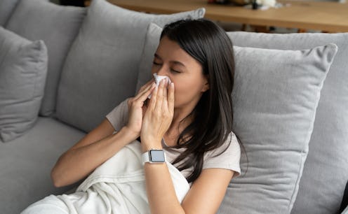 A person in a white shirt lays in bed and blows her nose. Spring allergies can definitely feel much ...