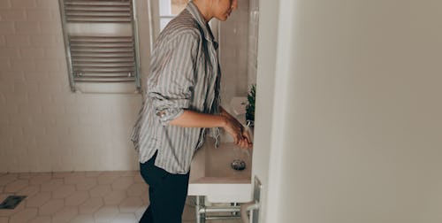 A woman in pajamas washes her hands. Staying inside can mean you relax your routines, but some regul...