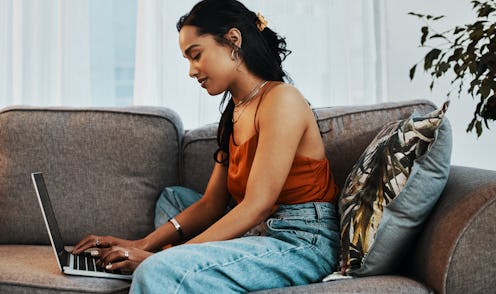 A woman sitting by her laptop while she is social distancing